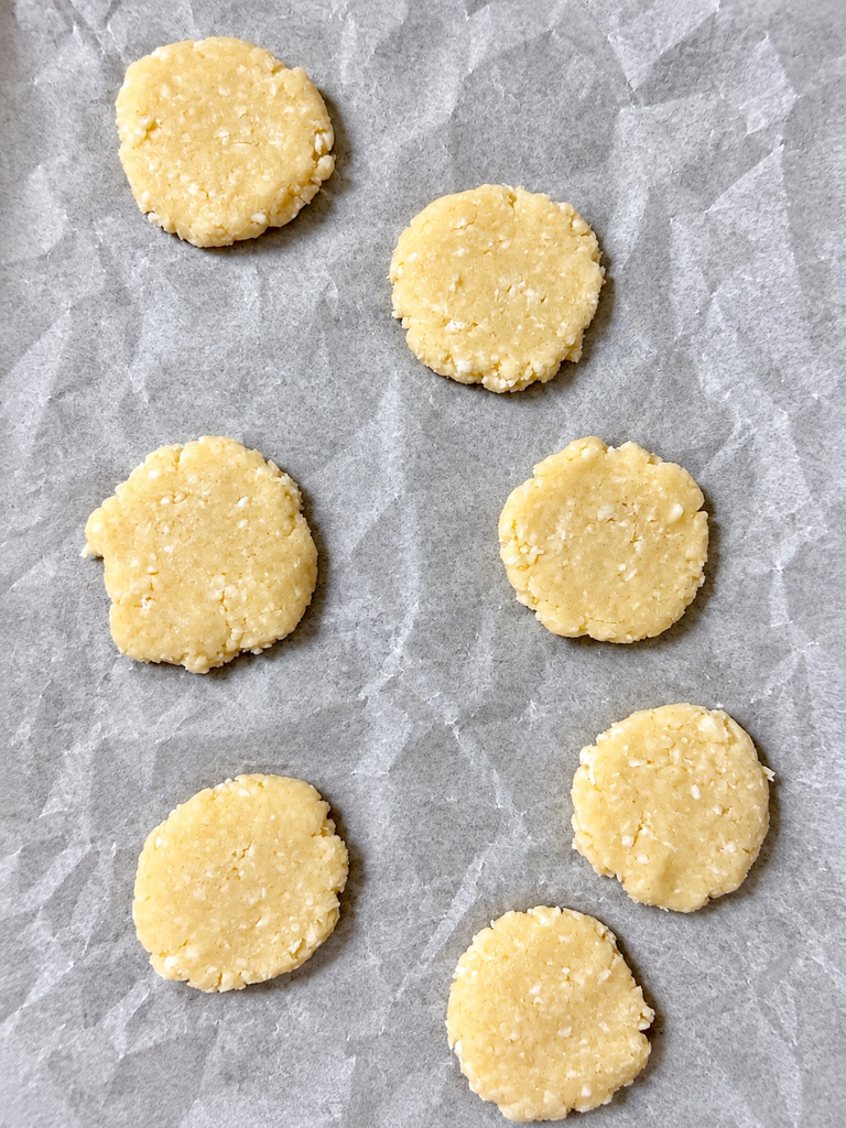 Shaped coconut cookies on parchment paper before baking