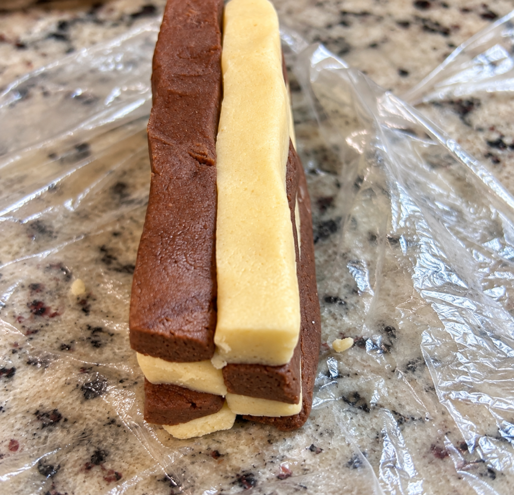 Vanilla and chocolate dough strips arranged in alternating layers to make checkerboard cookies
